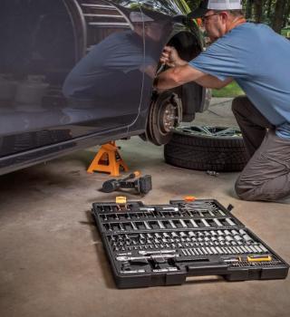 GW90MCBMTS 185 Piece 1/4", 3/8” & 1/2" Drive 90T SAE/Metric Mechanics Hand Tool Set showing the set with the case open and a person using the tools on a car.