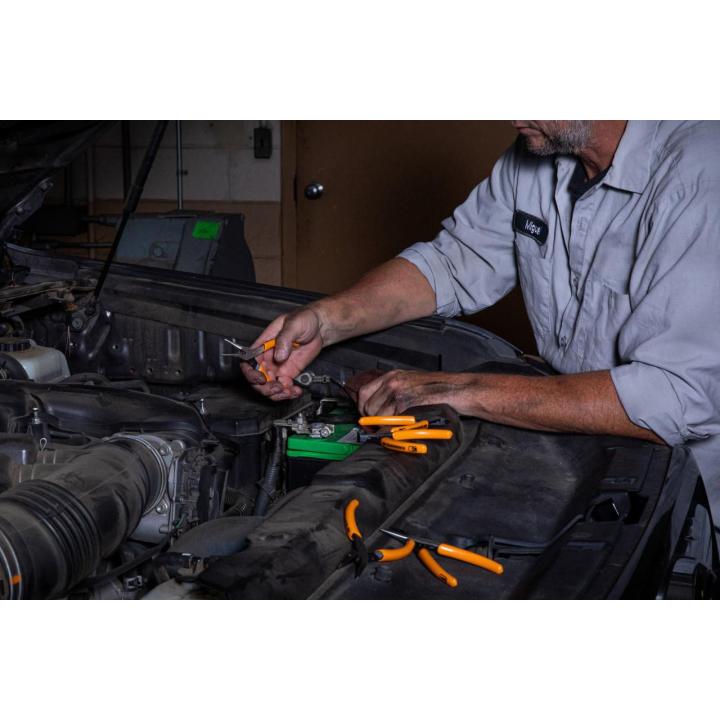 Man using GEARWRENCH 89730 5 piece mini plier set to work on a car engine
