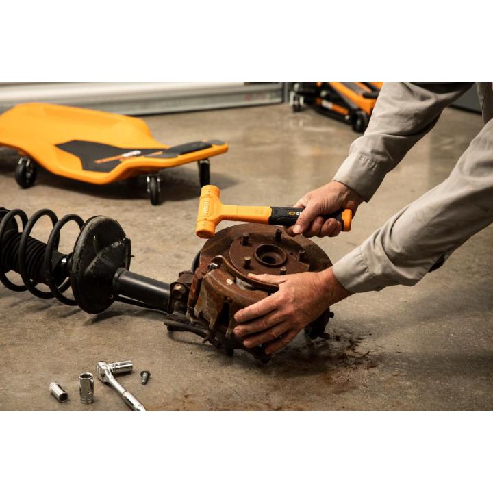 18 oz. Dead Blow Hammer being used by a person on a brake drum in a shop setting
