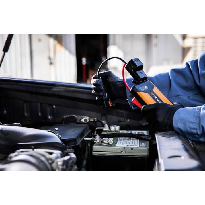 GEARWRENCH GWLBJ12 battery jumper and power bank being used with the included jumper cables to jump a car battery