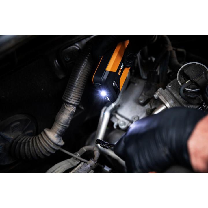GEARWRENCH GWLBJ12 battery jumper and power bank flashlight feature being used to shine light into a recessed area of a car engine bay