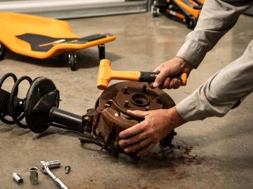 18 oz. Dead Blow Hammer being used by a person on a brake drum in a shop setting